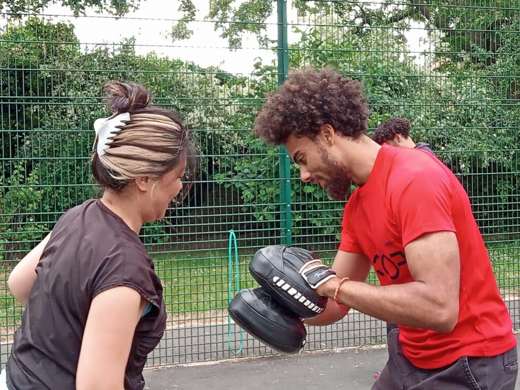 SWBW coach holding pads for a member during a BoxFit session